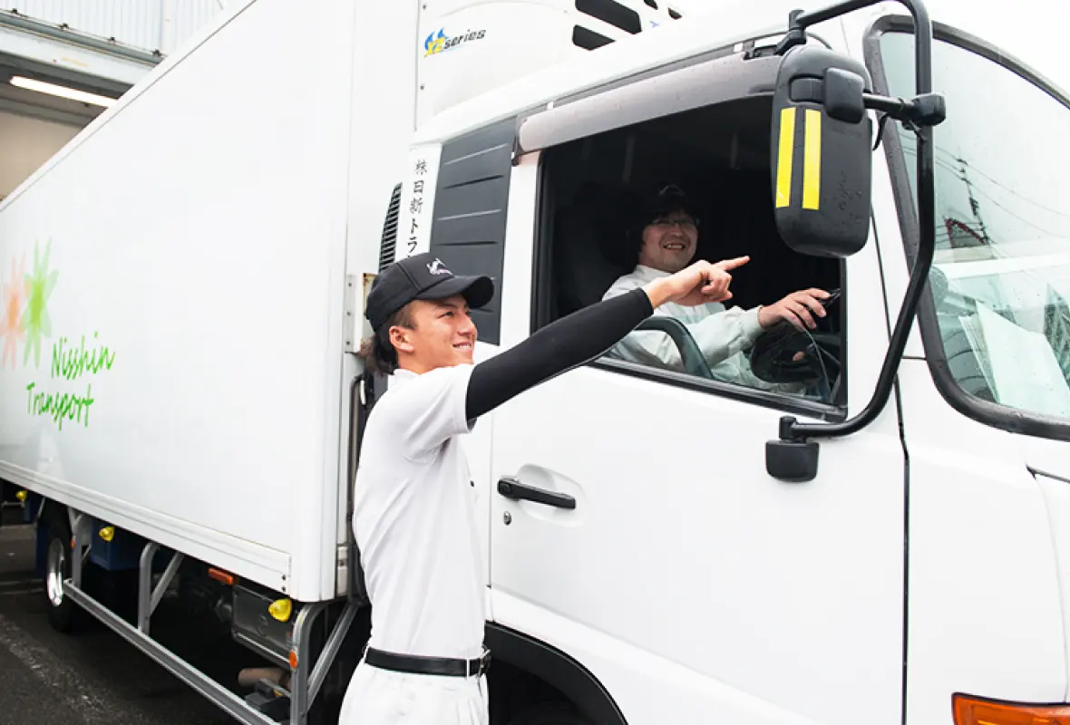 トラックの運転席で指導を受けている写真